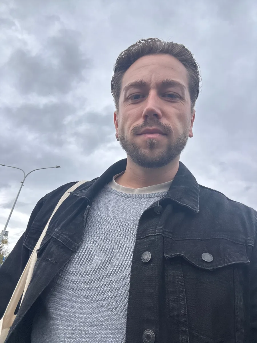 Brent kijkt in de camera onder een bewolkte hemel